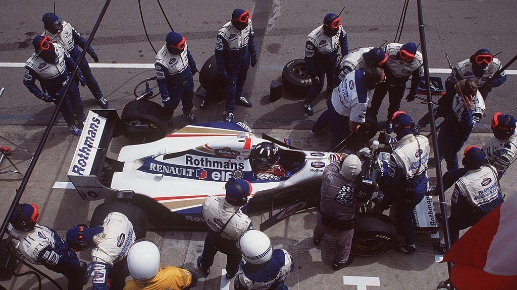 Mechanics assess the damage on Damon Hill's car in the pits
