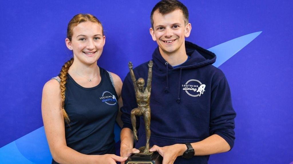 James Hadley with his team mate holding an award 