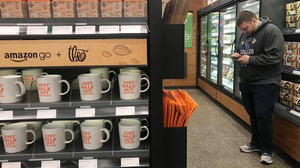 A shopper is seen using his phone in the line-free, Amazon Go store