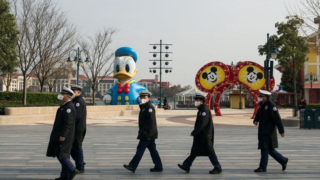 Staff workers wear protective masks in Shanghai Disneyland Park.