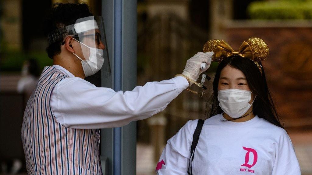 a visitor to Disneyland Japan has her temperature checked