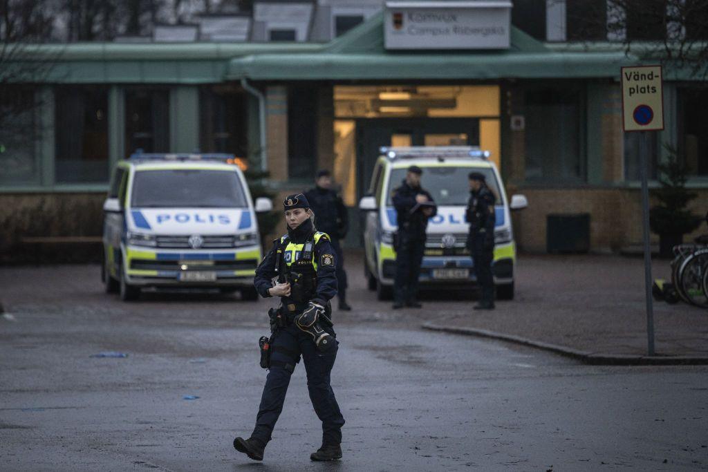 Police at the scene of the attack. Ten people - seven women and three men - were killed by the gunman.