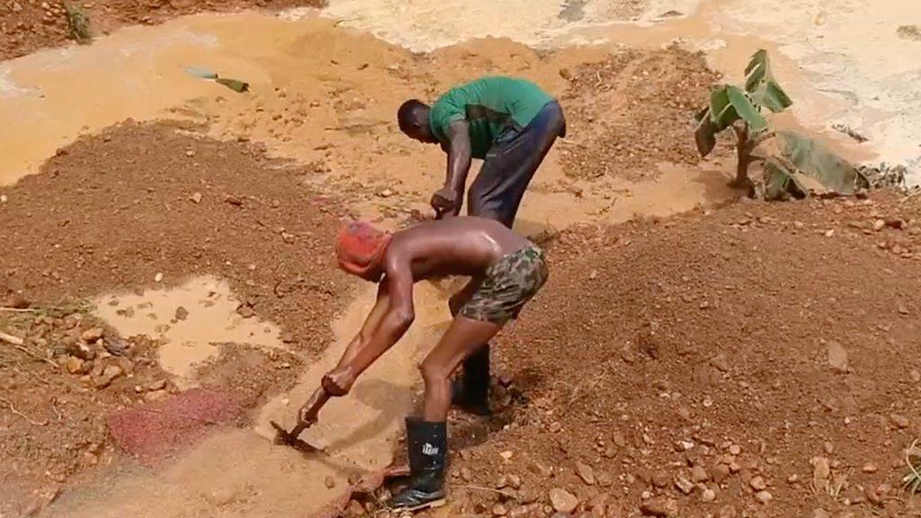 Gold miners shovelling in a river