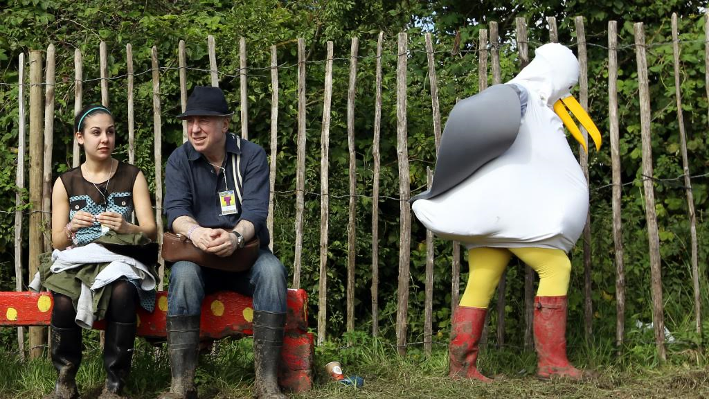 A seagull passes some non-seagulls at Glastonbury