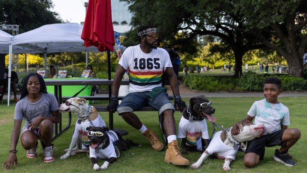 A family and their dogs with '1865' on the mans shirt