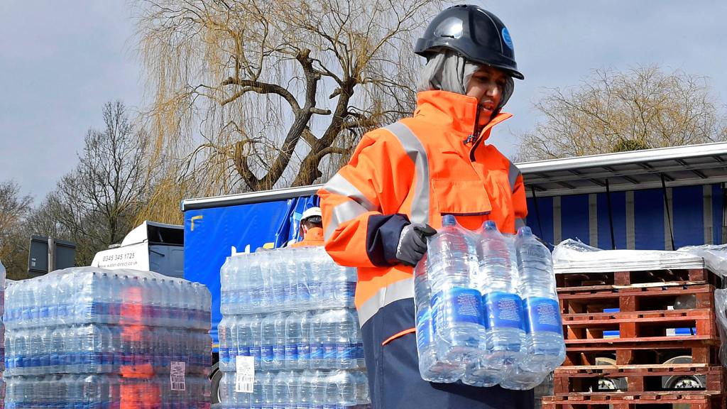 A Thames Water operative collects bottled water for distribution in Hampstead in London, Britain