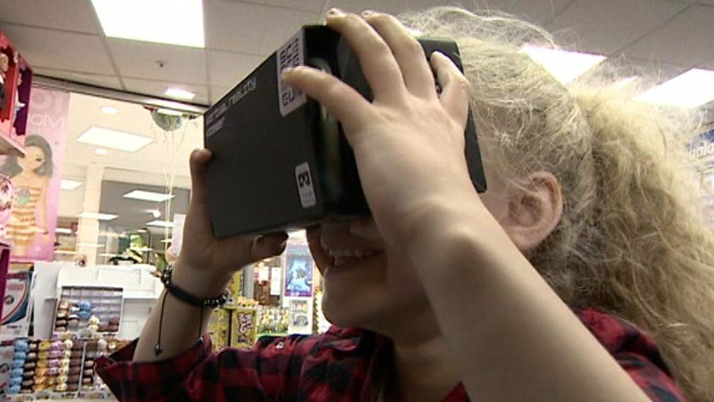 Young girl tests the cardboard VR headset