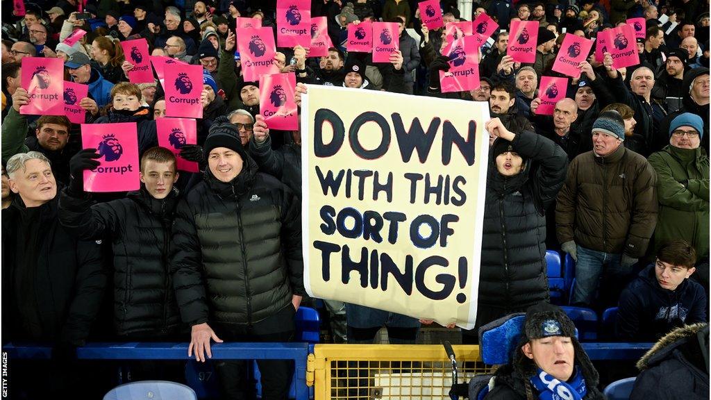 Fans holding up protest cards and banners at Goodison Park