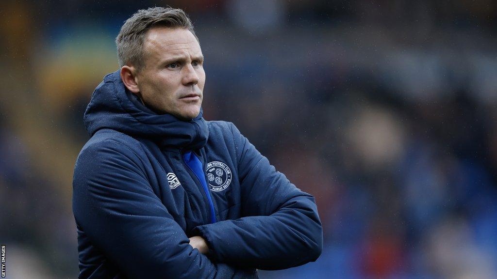 Shrewsbury Town manager Matt Taylor looks on from the dugout during a match