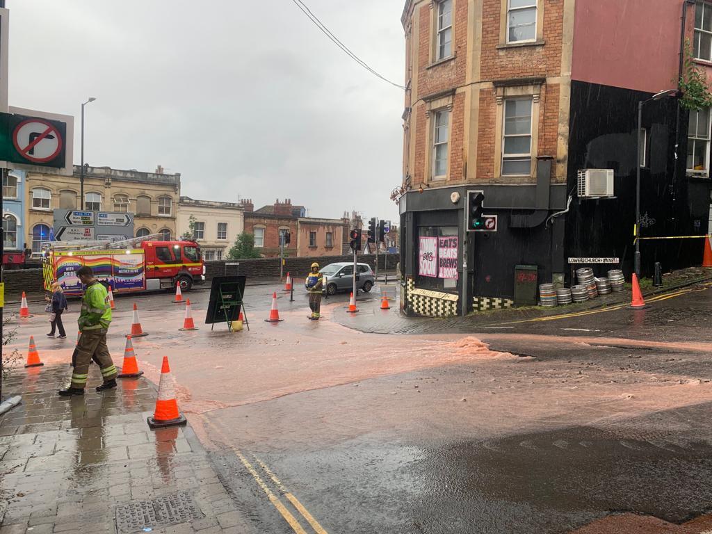 Burst water main at the bottom of St Michael's Hill in Bristol. Two firefighters and a fire truck are in shot