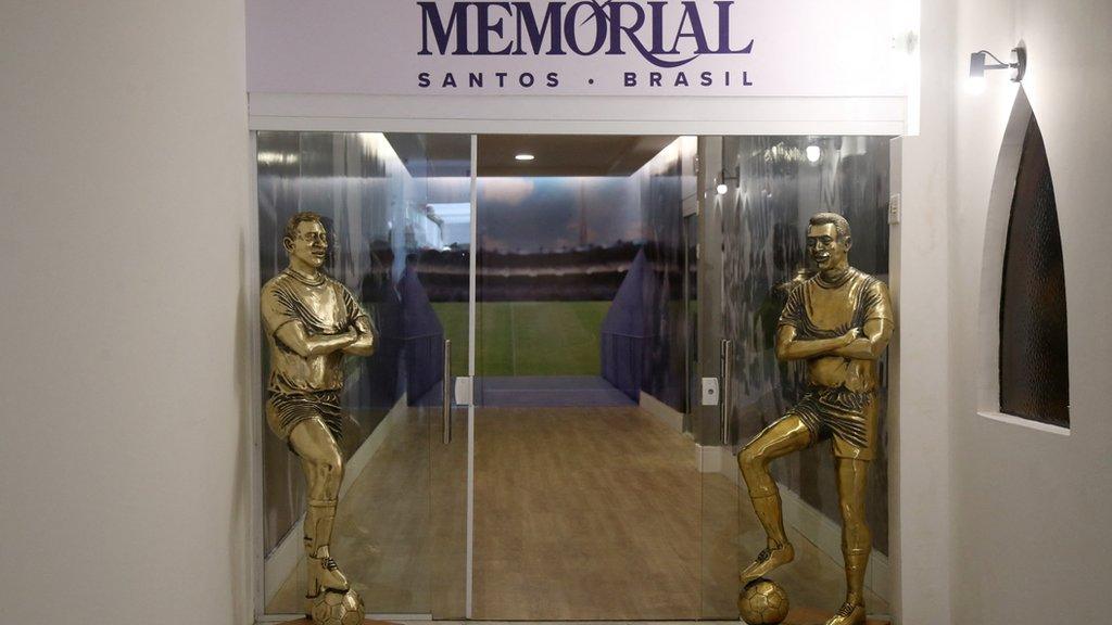 Two life-sized bronze statues stand at the entrance to Pele's tomb on Tuesday following a private ceremony at the Ecumenical Memorial Necropolis cemetery in Santos