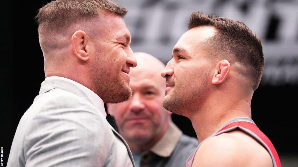 Conor McGregor grins at Michael Chandler during a face-off