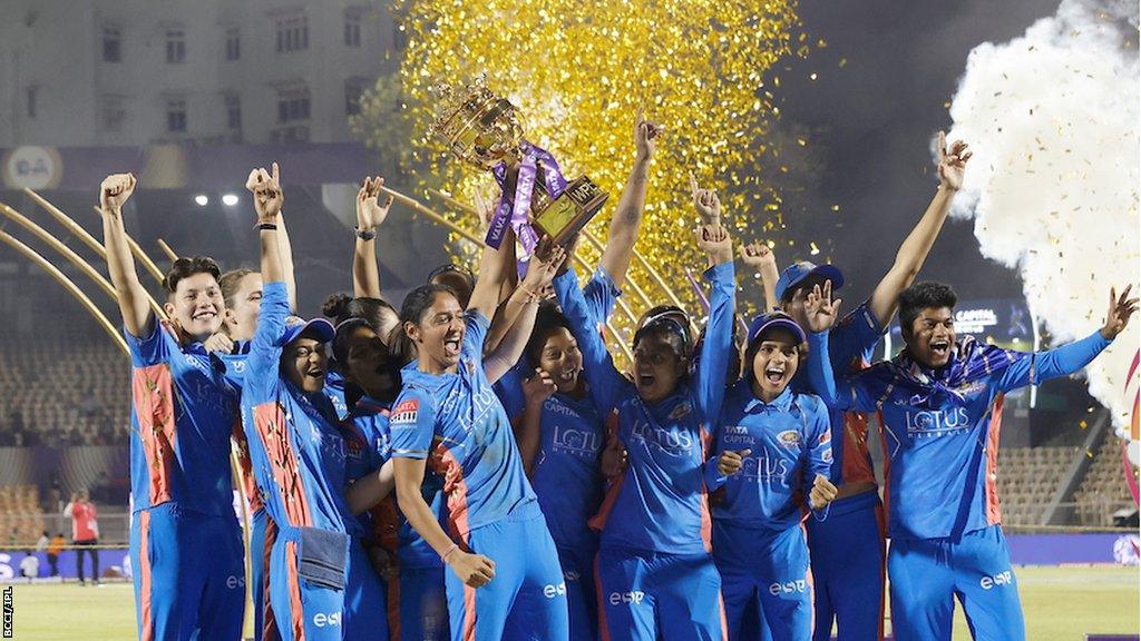 Mumbai Indians women's team celebrating with the WPL trophy