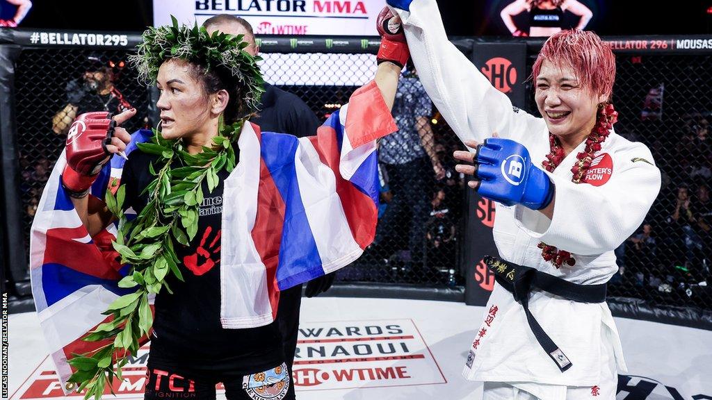 Ilima-Lei Macfarlane and Kana Watanabe raise their hands together following their bout