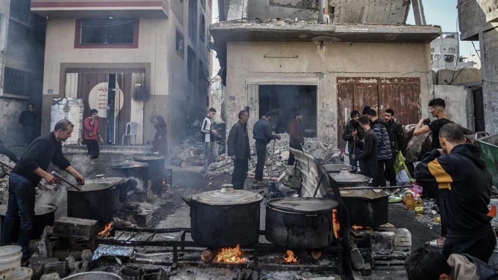 Volunteers prepare food for Palestinian families displaced to Rafah in southern Gaza