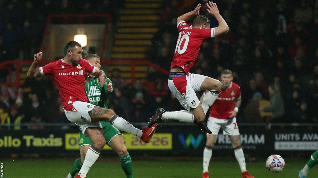 Paul Mullin takes evasive action as fellow striker Ollie Palmer puts Wrexham ahead against Yeovil