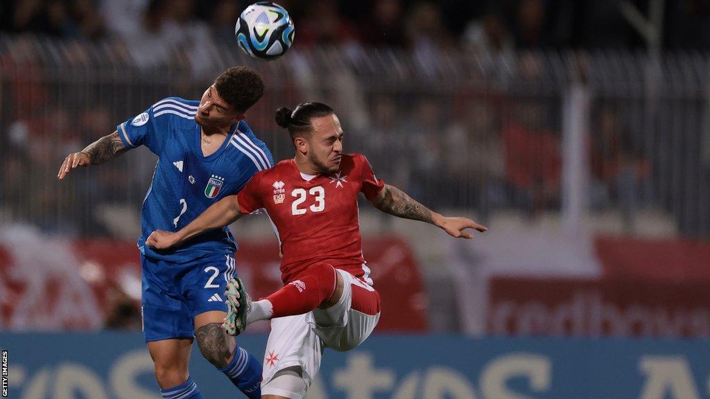 Giovanni Di Lorenzo of Italy heads the ball away from Jodi Jones of Malta