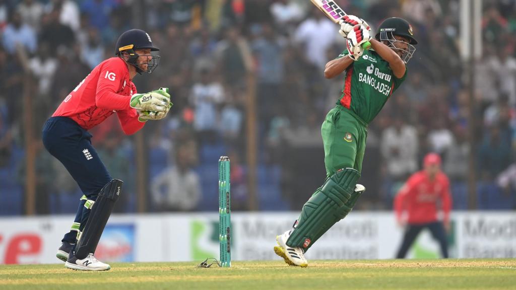 Bangladesh batsman Najmul Hossain Shanto plays a shot, watched by Jos Buttler during the 1st T20 International between Bangladesh and England at Zahur Ahmed Chowdhury Stadium