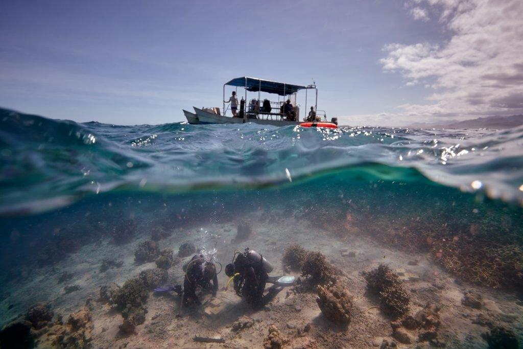 divers-in-water-with-a-boat-on-the-water.