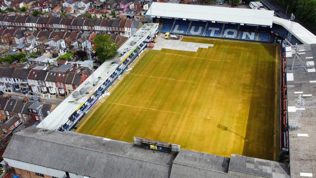 An aerial picture taken on May 31, 2023 shows Luton Town's Kenilworth Road stadium, in Luton, as members of the ground staff remove the pitch lines and cover the grass during the end of season works.