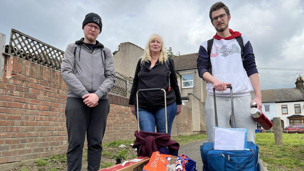 Heidi Dodson and her two sons with their possessions in suitcases.