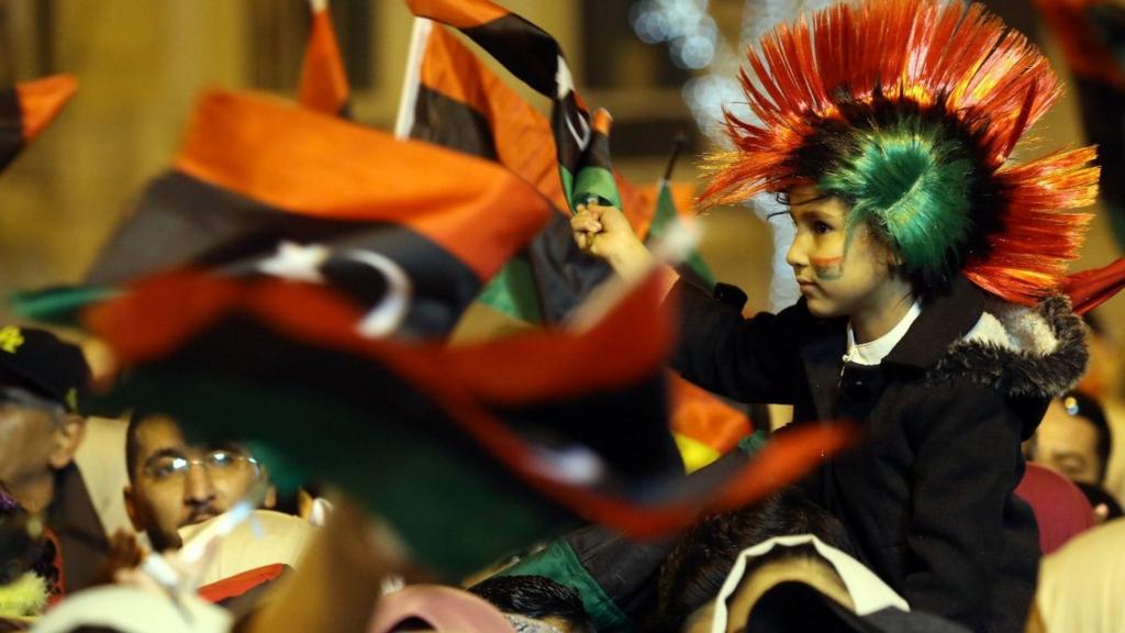 Libyans wave national flags as they attend a celebration marking the seventh anniversary of the Libyan revolution which toppled late leader and strongman Moamer Kadhafi, in the capital Tripoli's Martyrs Square on February 17, 2018