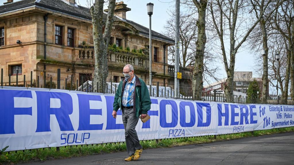 Man walking past free food sign in Glasgow