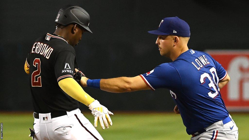 Arizoana Diamondbacks batter Geraldo Perdomo is tagged out by Texas Rangers fielder Nathaniel Lowe