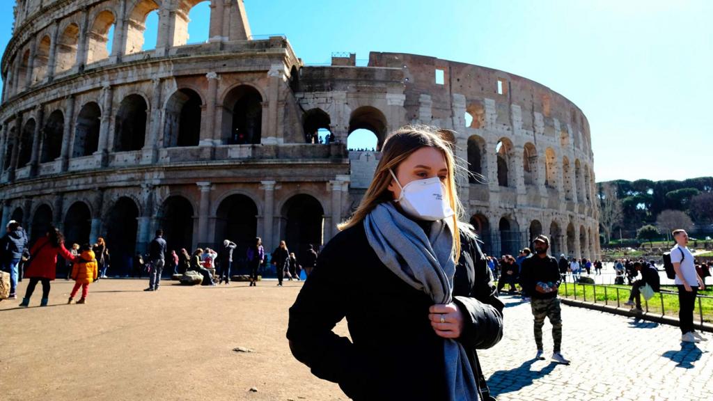 Tourist in mask outside Colosseum in Rome - 28 February