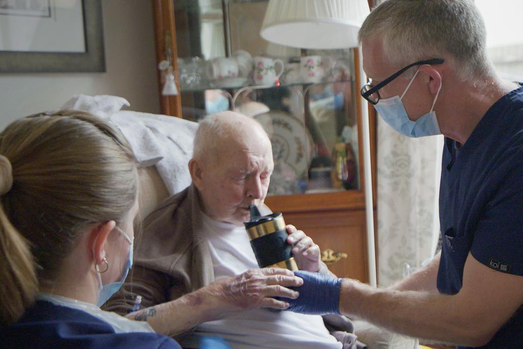 Prof Lasserson helps Ted have a drink before starting the medical treatment