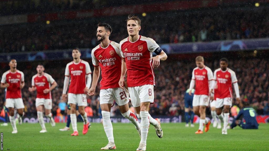 Arsenal players celebrate after scoring against PSV