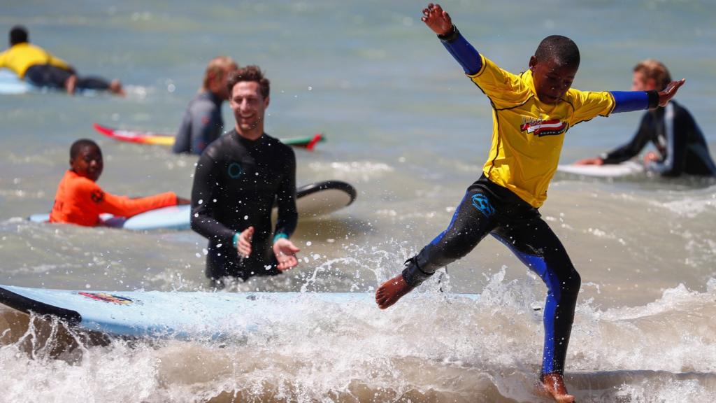 A South African child in the Waves For Change program wipes out whilst surfing during the Waves For Change Ocean Festival at Monwabisi beach in Cape Town, South Africa, 03 February 2018