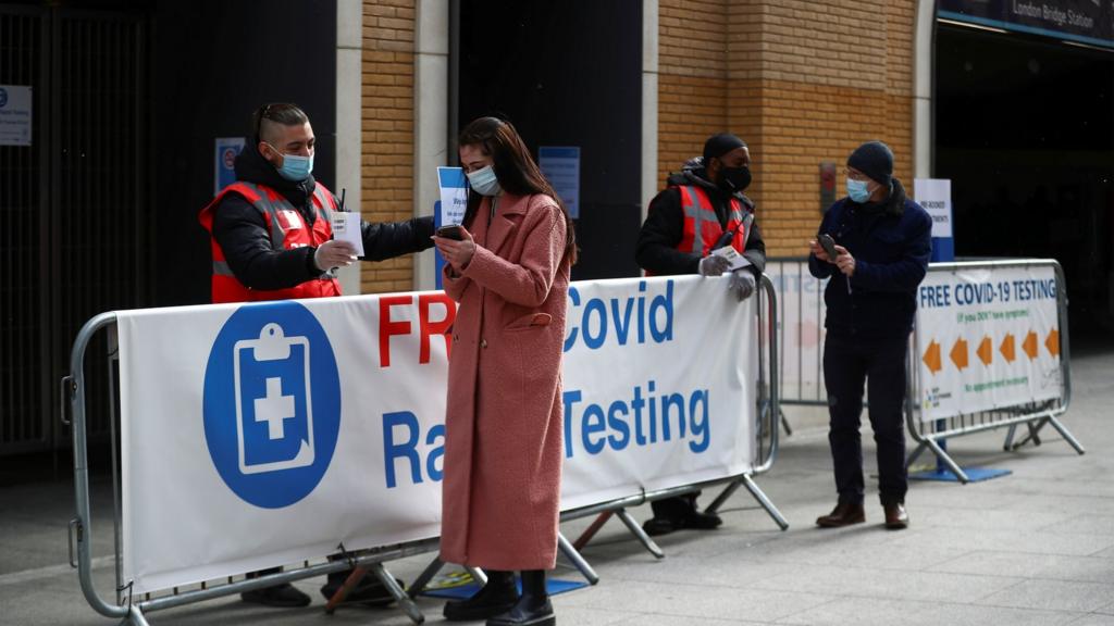 People stand outside a coronavirus test centre at London Bridge Station