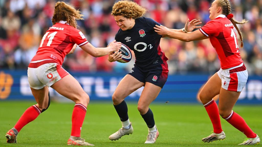 Ellie Kildunne of England holds off Carys Cox and Hannah Jones of Wales