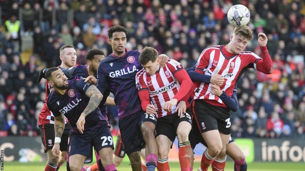 A set piece is headed clear during Lincoln v Stevenage