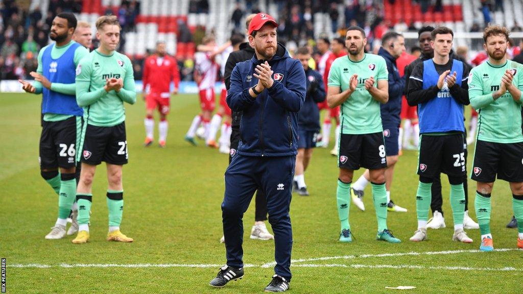 Darrell Clarke and Cheltenham players applaud fans on the pitch at full-time