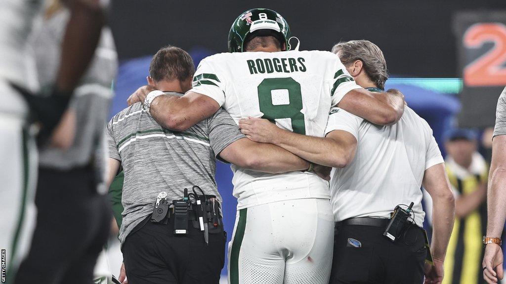 Aaron Rodgers is helped off the field