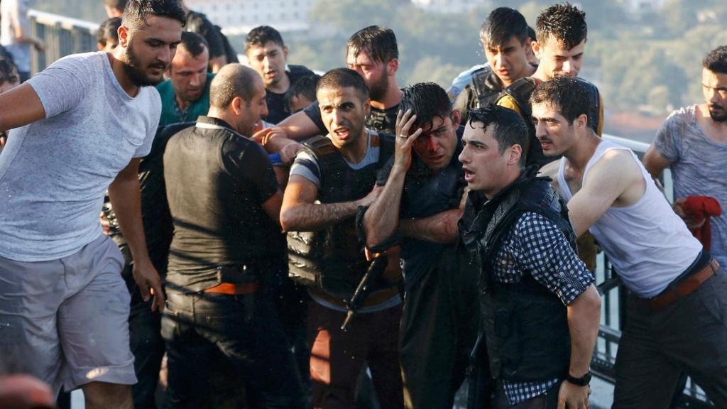 Policemen protect a soldier from a mob on the Bosphorus bridge in Istanbul on 16 July 2016