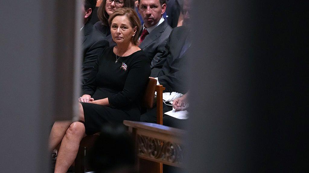 Graham's sister, Darline Graham, has been appointed to fill his South Carolina US Senate seat. She wears a black dress as she sits in the front row of pews.