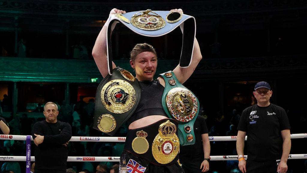 Lauren Price poses with her world titles after beating Natasha Jonas