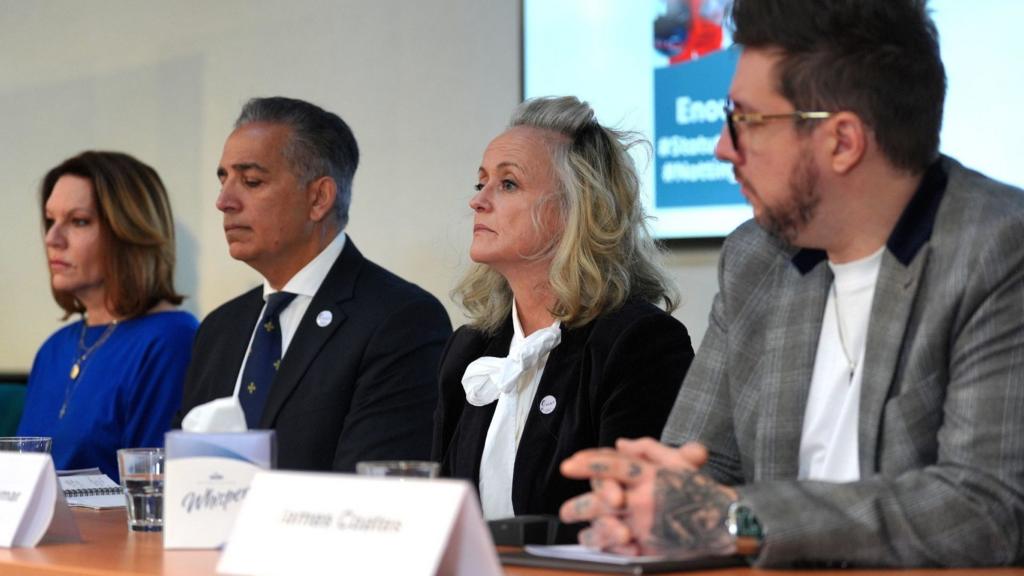 Emma Webber, the mother of Barnaby Webber, Dr Sanjoy Kumar and Dr Sinead O'Malley, the parents of Grace O'Malley-Kumar and James Coates, speaking to the media during a press conference. They are sitting at a table with name cards in front of them and a video screen on the wall behind them