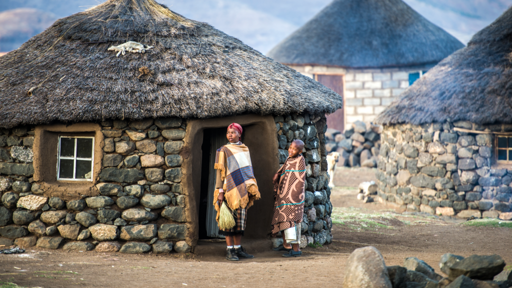 Children wrapped in blankets standing in a village in Lesotho