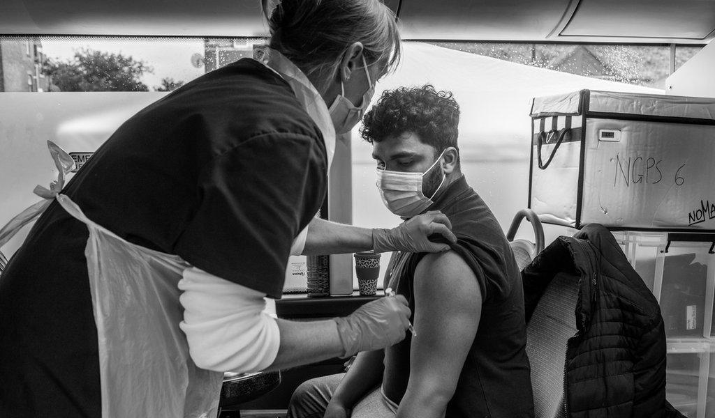 Man about to get vaccinated on vaccination bus on West Road