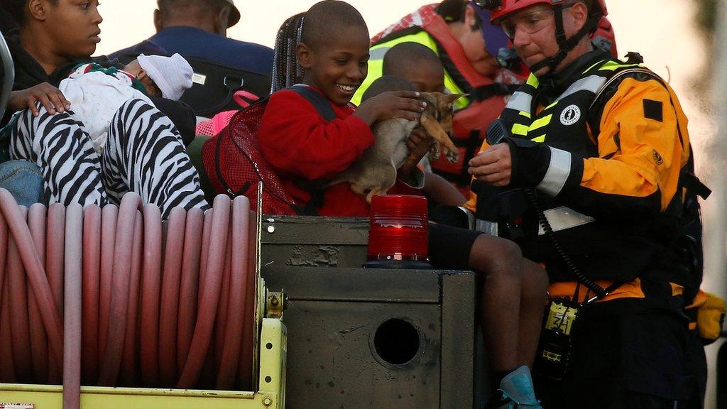 A member of FEMA hands a child his dog on a truck as people are evacuated from a flood area as a result of Hurricane Mathew in Lumberton, North Carolina, U.S. October 10, 2016