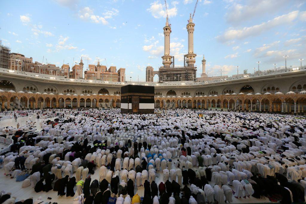 Worshippers bowing down in prayer in front of the Kaaba