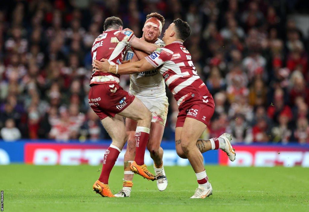 Paul Seguier is tackled by Jake Wardle (left) and Tyler Dupree (right)