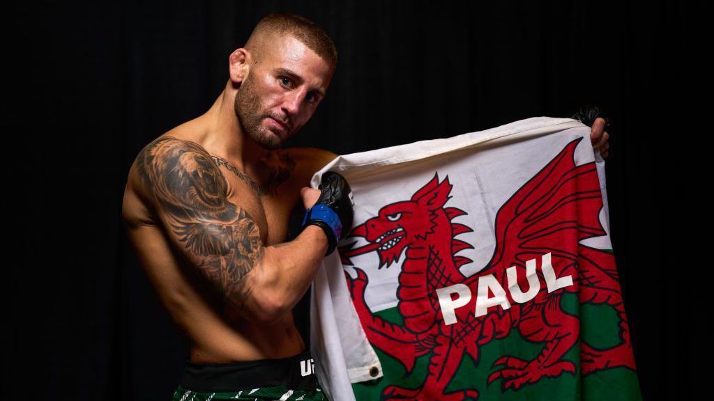 Oban Elliott with his Welsh flag with his father's name on it