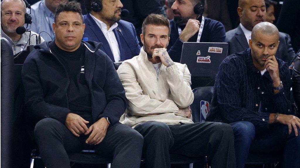 Former footballers Ronaldo and David Beckham and ex-basketball player Tony Parker sit courtside during the Brooklyn Nets v Cleveland Cavaliers in Paris