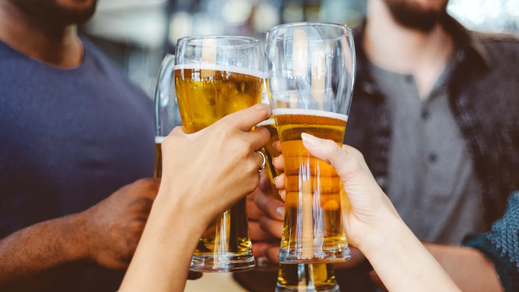 Four people holding pints of beer