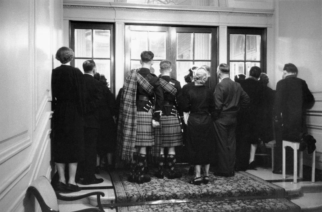 Latecomers and people without tickets crowd round the doors to watch a charity show of the new collection by French fashion designer Christian Dior, at a ballroom in Gleneagles, Perth and Kinross, Scotland, May 1955.